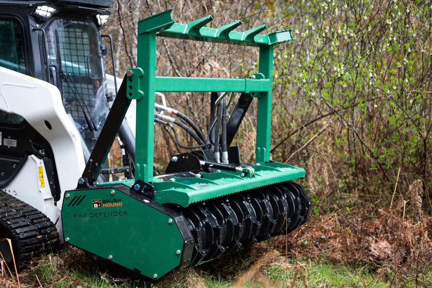 Skid steer forestry mulcher head working through brush